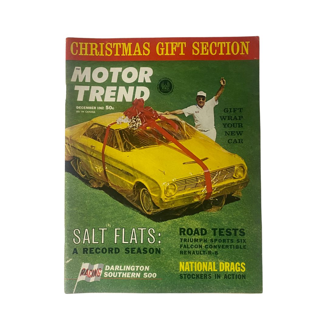 Cover of VTG Motor Trend Magazine December 1962 titled 'Salt Flats: A Record Season' featuring a yellow car wrapped in a red bow, promoting gift-wrapping options for cars.