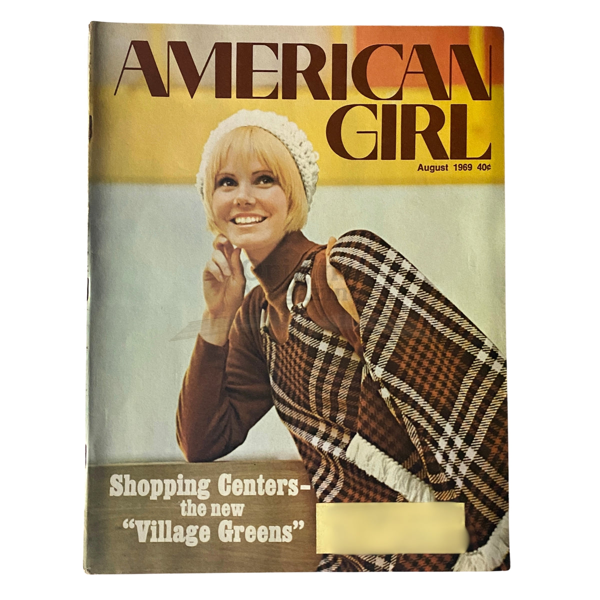 Cover of American Girl Magazine from August 1969 featuring a blonde model in a white knitted hat and plaid outfit, with the headline 'Shopping Centers: The New Village Greens.'