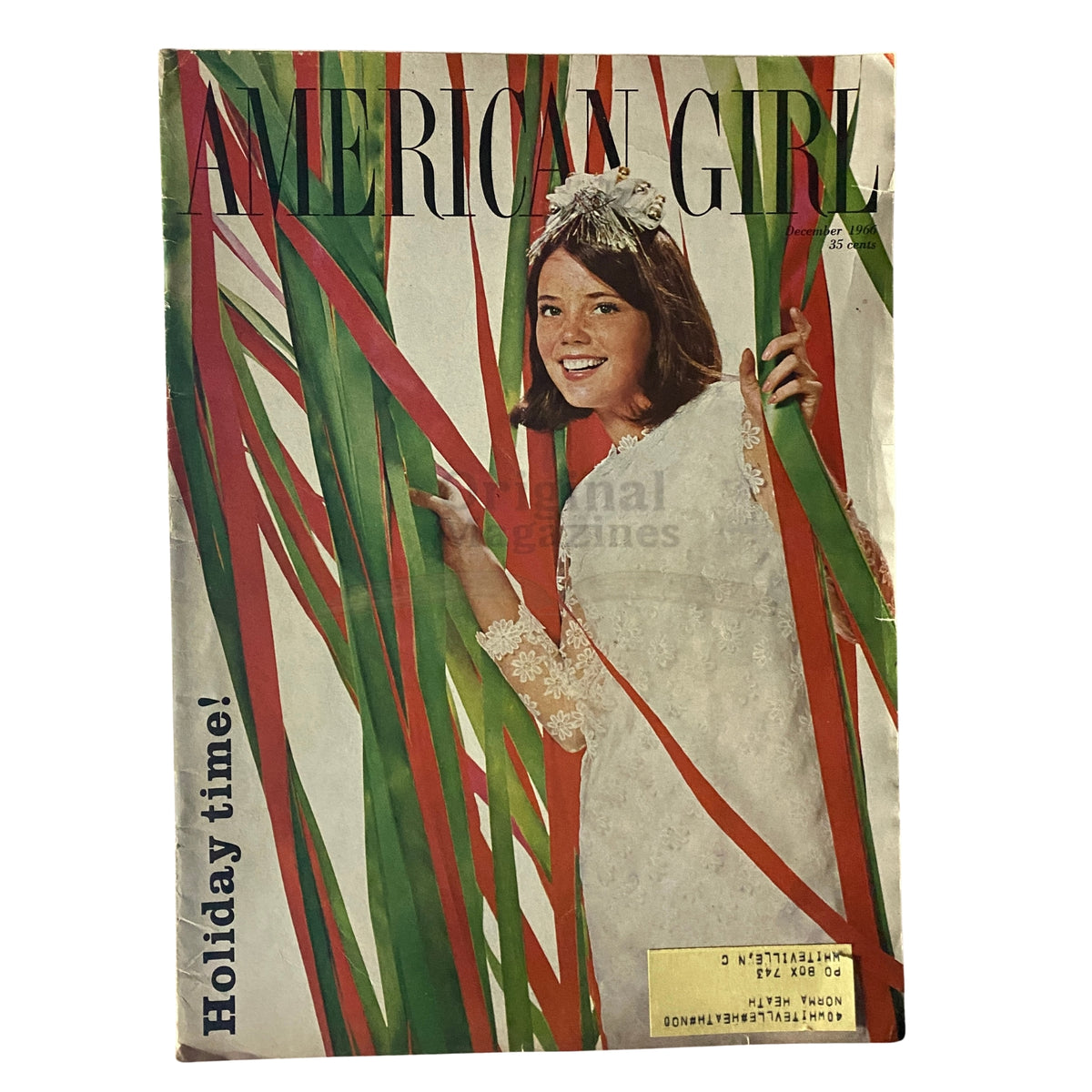 Cover of American Girl Magazine December 1966 featuring a smiling girl amidst red and green decorations, emphasizing the holiday theme. Titled 'Holiday time!'.