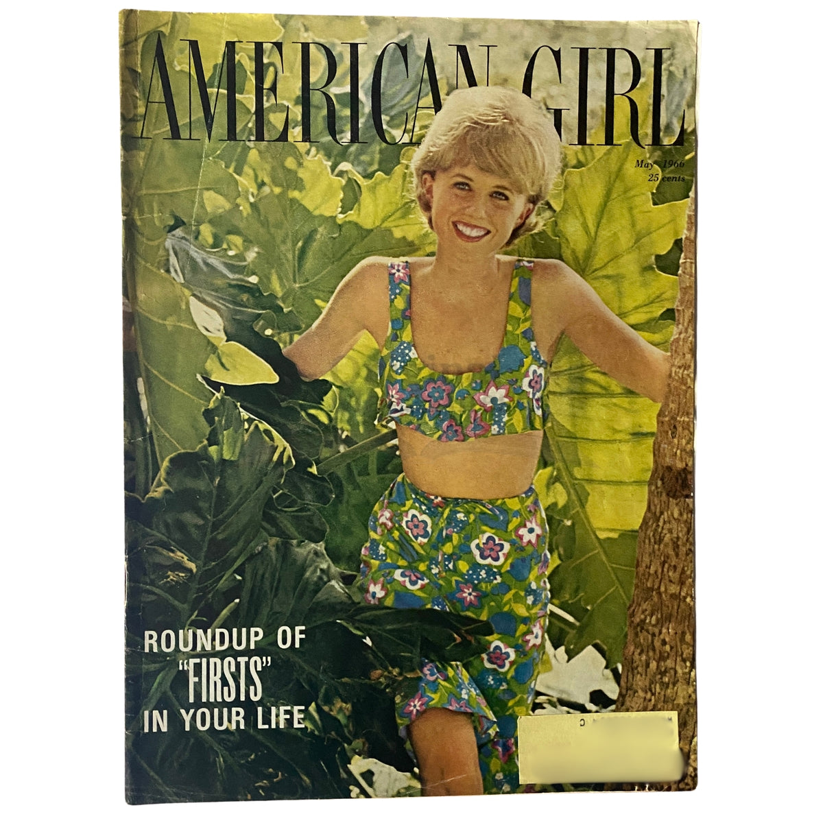 Cover of American Girl Magazine May 1966 featuring the title 'Roundup of "Firsts" in Your Life' with a young girl in a colorful floral two-piece outfit against a tropical background, showcasing vintage 1960s style.