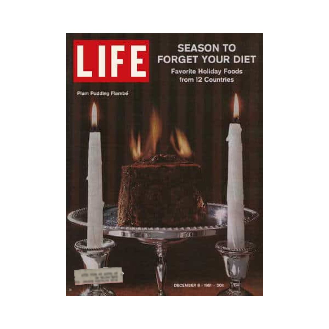 Cover of Life Magazine dated December 8, 1961, featuring a festive Plum Pudding Flambé, accompanied by lit candles, with the headline 'Season to Forget Your Diet' discussing favorite holiday foods from 12 countries.