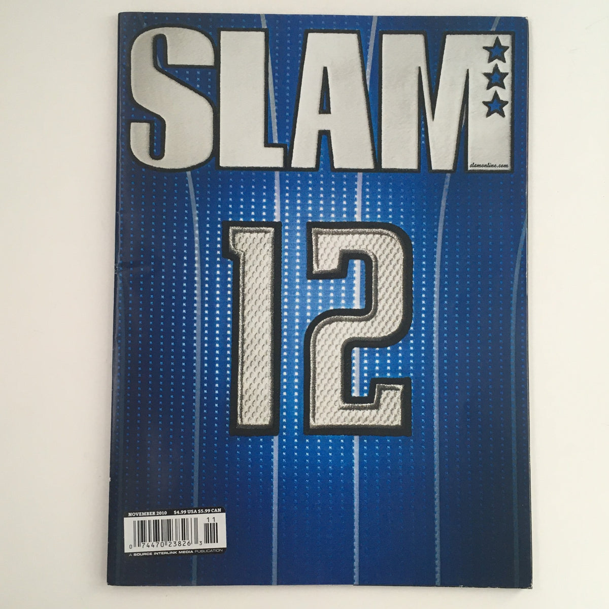 Cover of Slam Magazine November 2010 featuring the title 'SLAM 12' on a blue background, part of the Stephen Curry and Ricky Rubio edition.