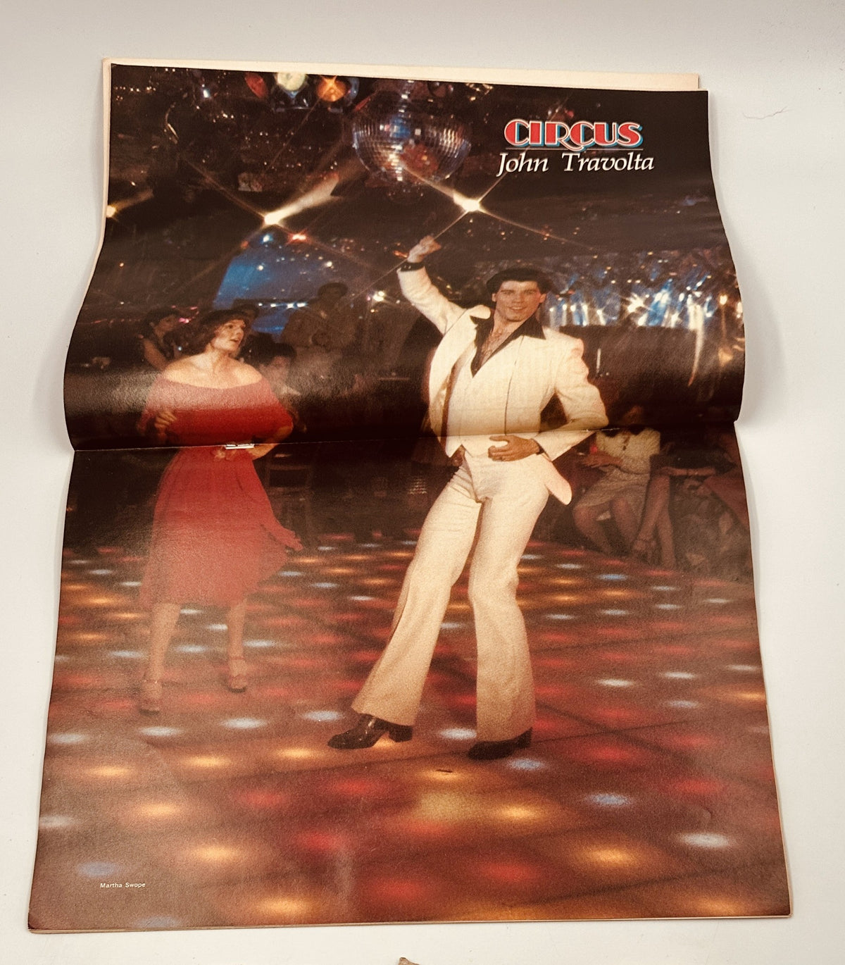 John Travolta poster featured in Circus Magazine May 11, 1978 highlighting the famous dance scene, showcasing a vibrant disco atmosphere.