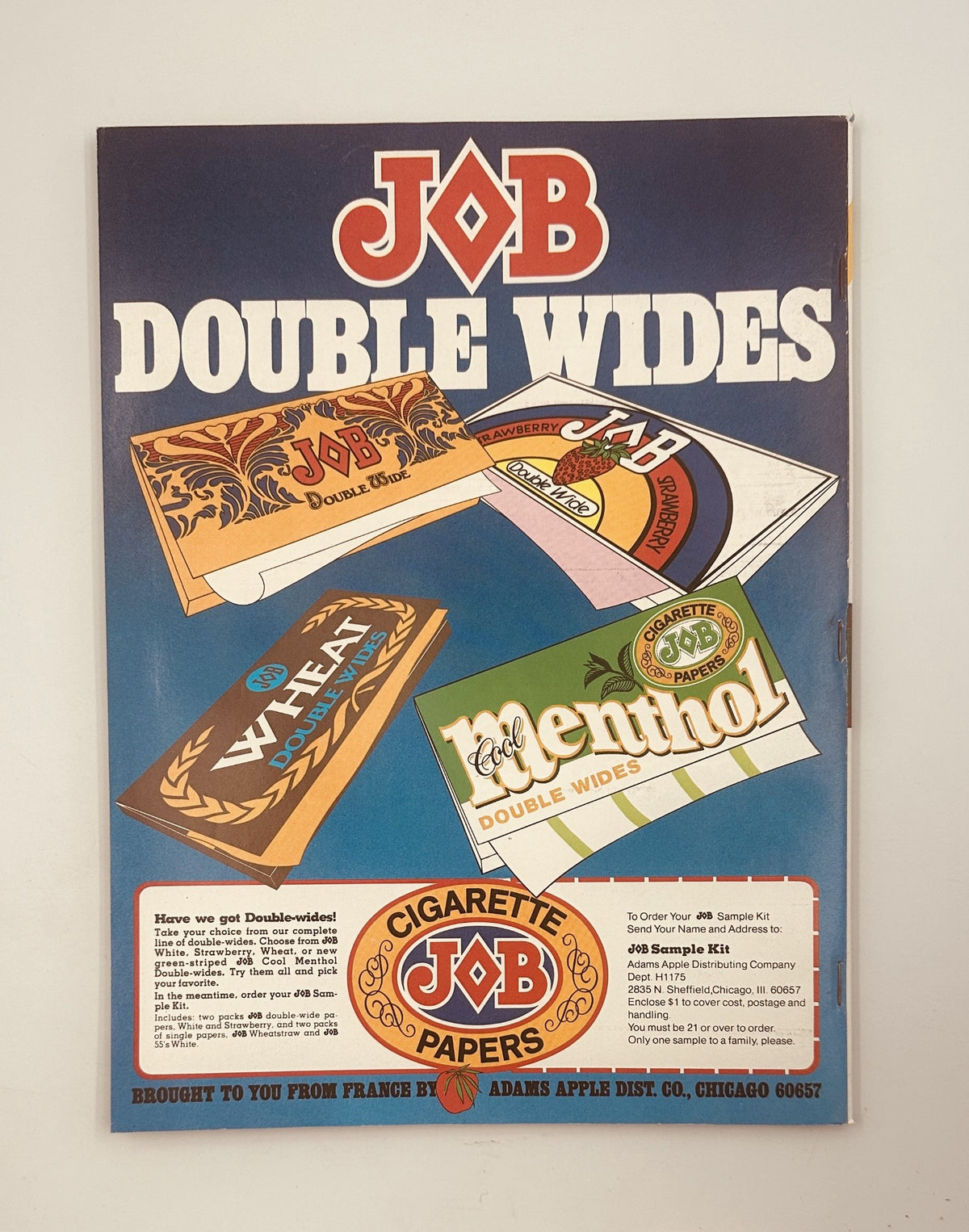 Advertisement for JOB Double Wide cigarette papers featured in High Times Magazine December/January 1975. The colorful layout showcases various cigarette paper designs.