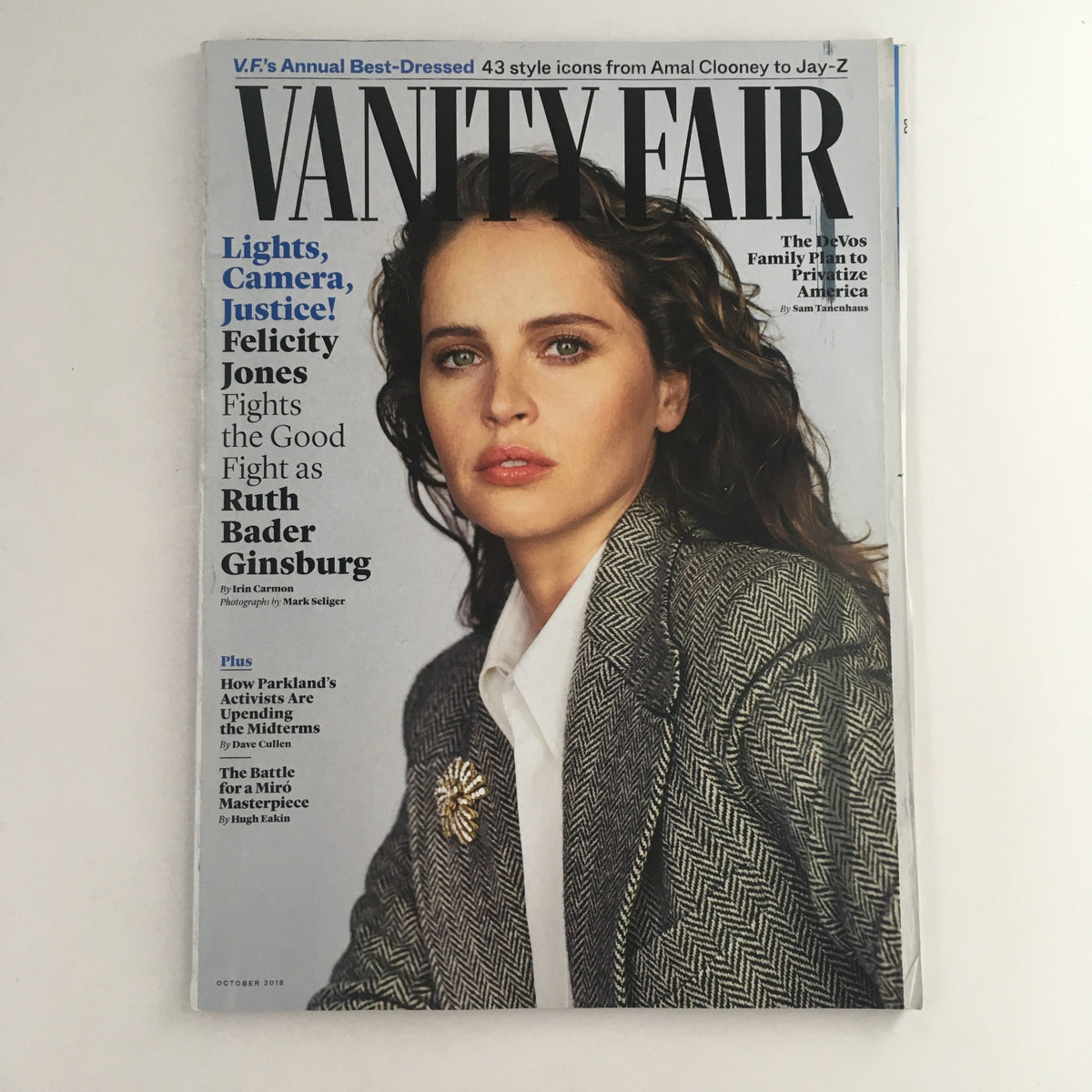 Cover of Vanity Fair Magazine October 2018 featuring Felicity Jones and Ruth Bader Ginsburg. The image showcases Jones in a stylish outfit with a prominent brooch, capturing the blend of Hollywood glamour and judicial influence.