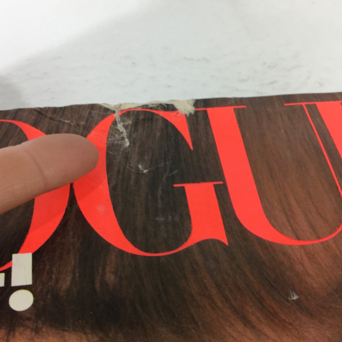 Close-up of damage on the top of the Vogue Magazine March 1983 cover, indicating signs of age with a small tear and wear, characteristic of vintage magazines.
