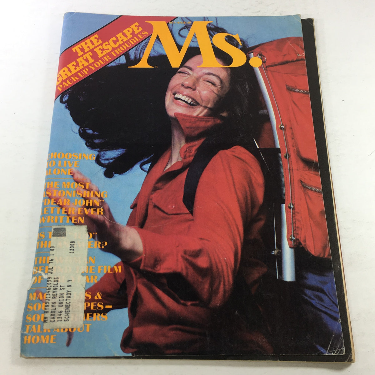 Vintage Ms. Magazine, July 1975 issue cover titled 'The Great Escape Pack Up Your Troubles', featuring a joyful woman with flowing hair wearing a red jacket.