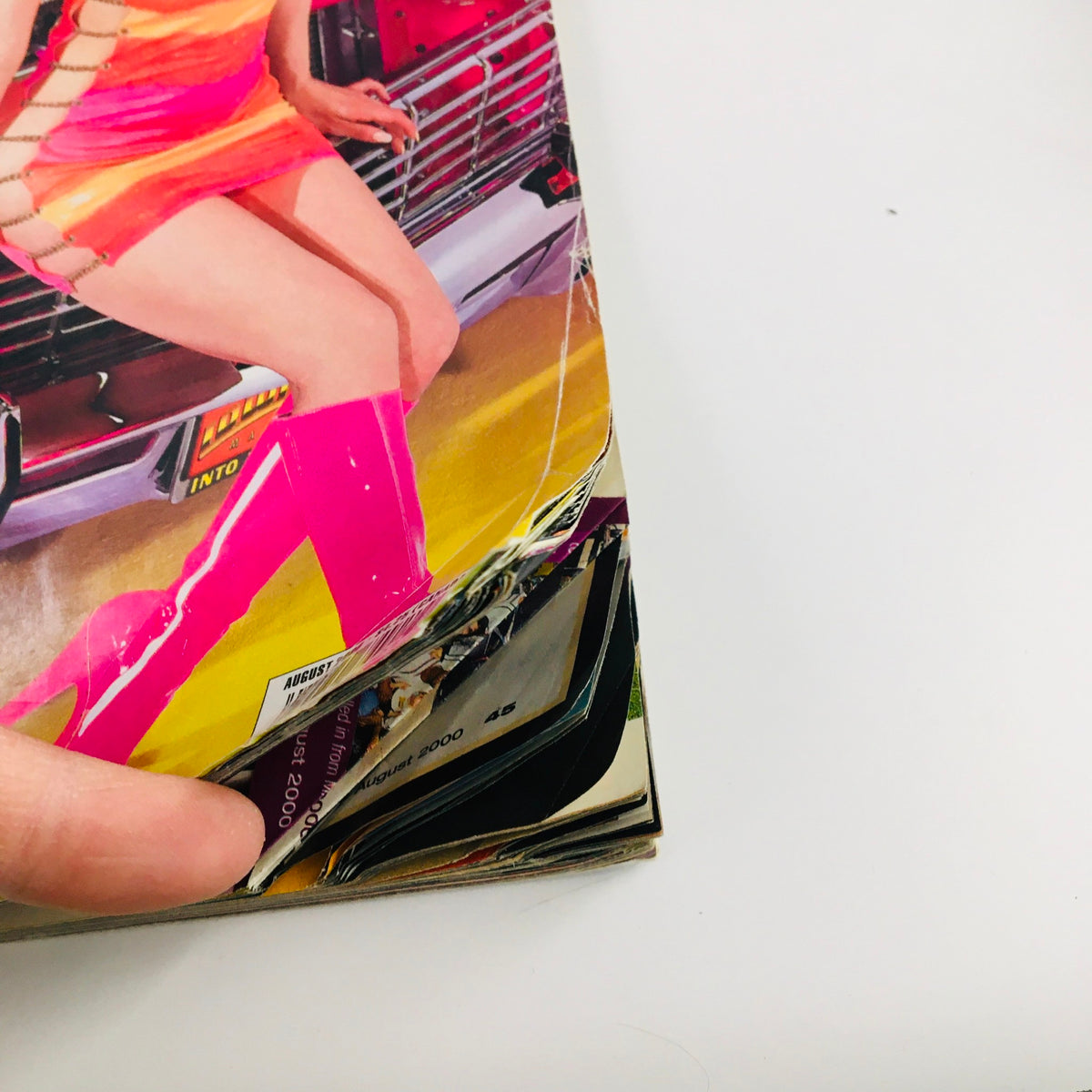 Close-up of the spine of LowRider Magazine August 2000 showing the wear and tear typical of vintage magazines, with focus on the article 'The Lifting of Gypsy Rose'.