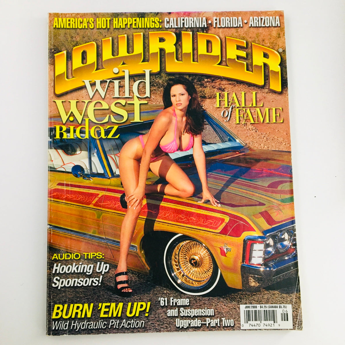 Cover of LowRider Magazine June 2000 featuring Wild West Ridaz and Hydraulic Pit Action, showcasing a model in a swimsuit beside a colorful lowrider car.