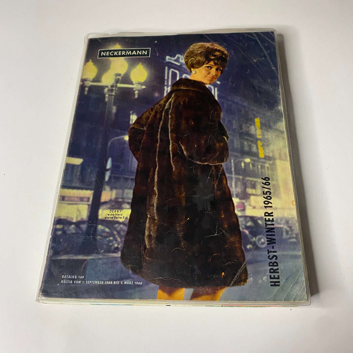 Cover of the 1965-1966 Neckermann Winter Catalog featuring a woman in a fur coat set against a night city backdrop, highlighting the fashion trends of the mid-1960s.