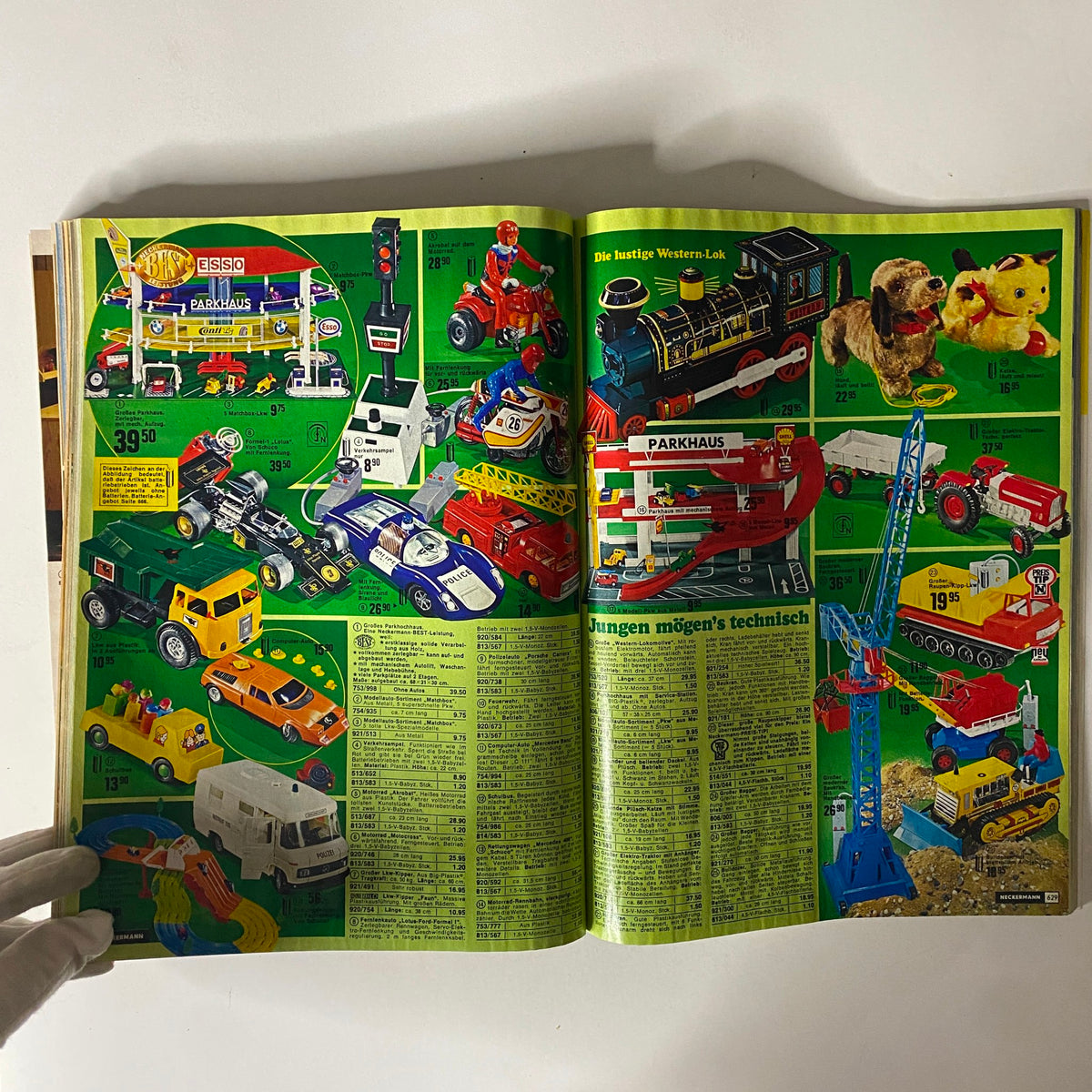 1974-1975 Neckermann Winter Catalog with a collection of popular toy vehicles, including cars, trains, and action figures on a lively background.
