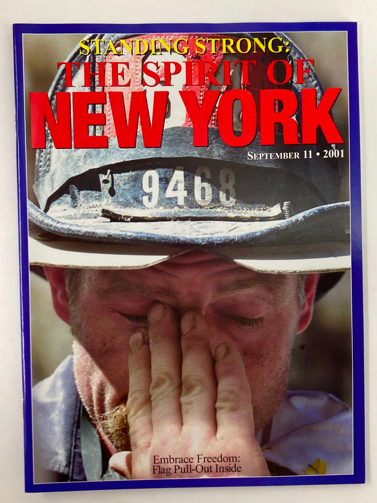 Cover of the magazine 'September 11 2001 Standing Strong: The Spirit of New York' featuring a firefighter in emotional reflection moments after the attacks.
