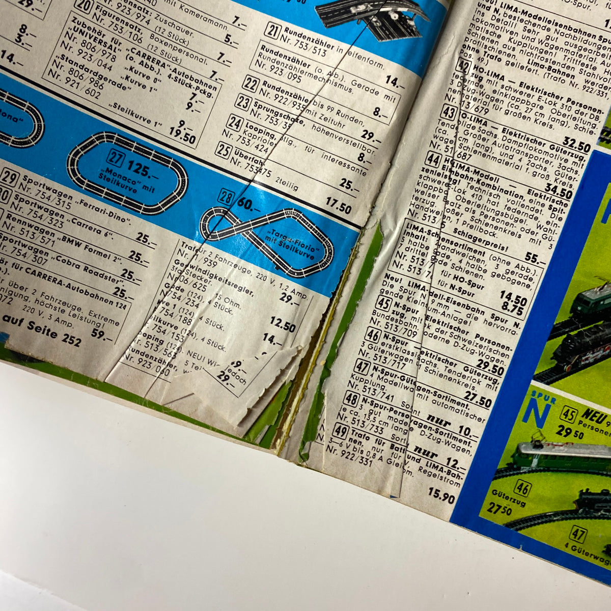 1973 Neckermann Summer Catalog close-up of toy car catalogs including racing tracks and model trains, capturing nostalgic playground items from the 70s.