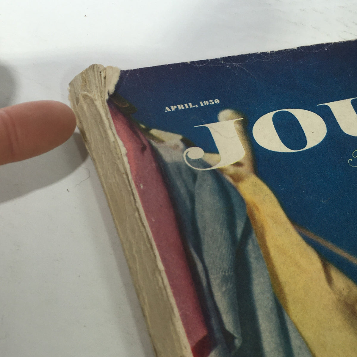 Close-up view of the corner of the VTG Journal Magazine from April 1950, featuring wear and tear typical of vintage publications, with the month and year prominently displayed.