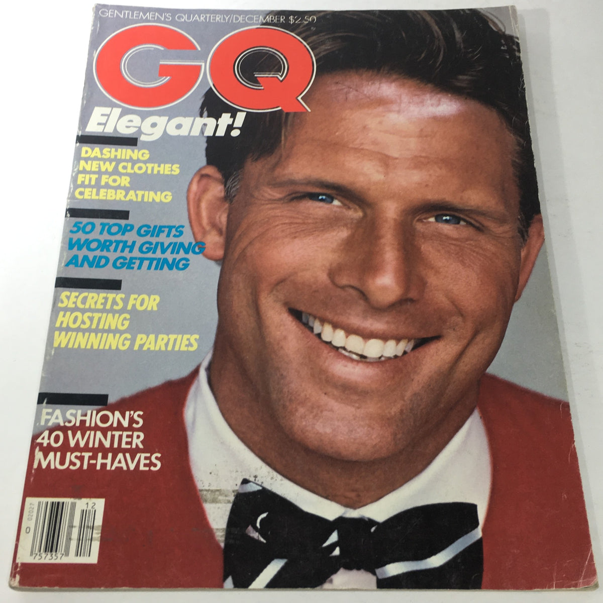 Cover of VTG GQ Magazine: Gentlemen's Quarterly December 1982 featuring a smiling model in formal attire with an elegant red jacket and bow tie, representing men's fashion trends of the early 80s.