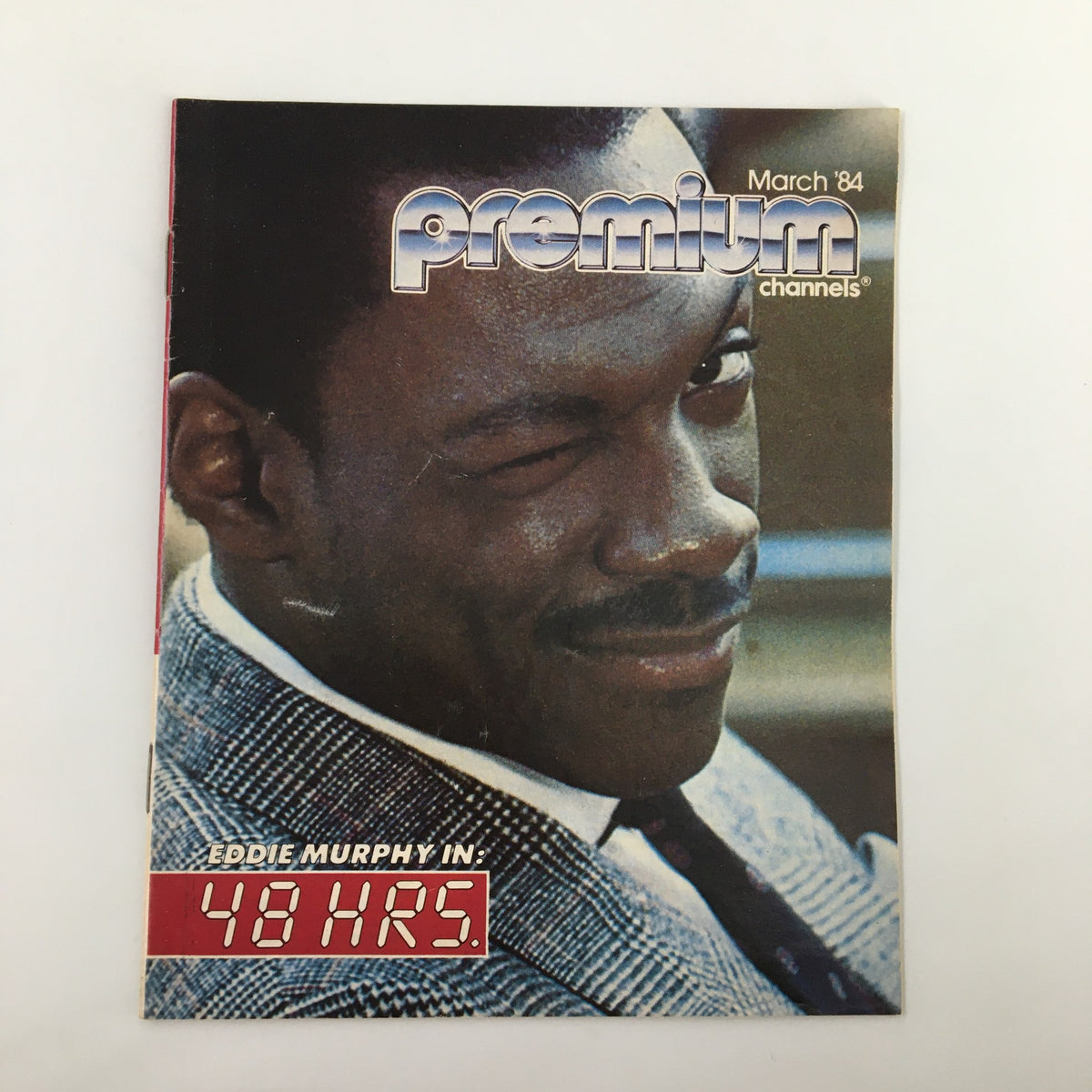 Vintage magazine cover titled 'VTG Premium Channels Mini Magazine March 1984' featuring Eddie Murphy in '48 Hrs.' showcasing a winking expression with a stylish background.