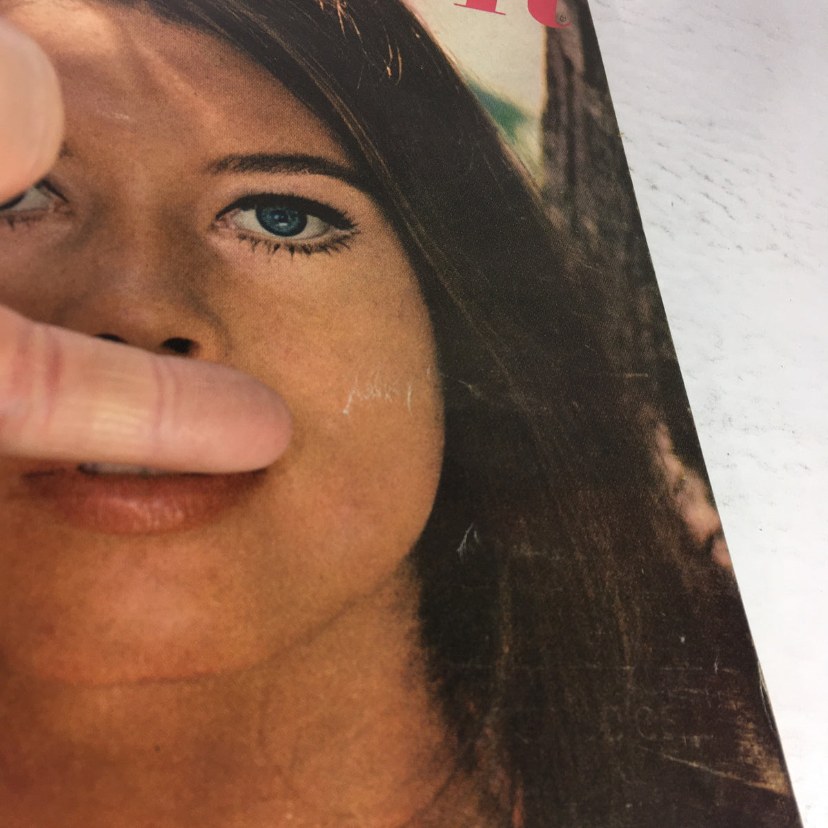 Close-up image of the VTG Glamour Magazine: October 1965 cover, highlighting a young woman's face with blue eyes and subtle imperfections, capturing vintage charm.