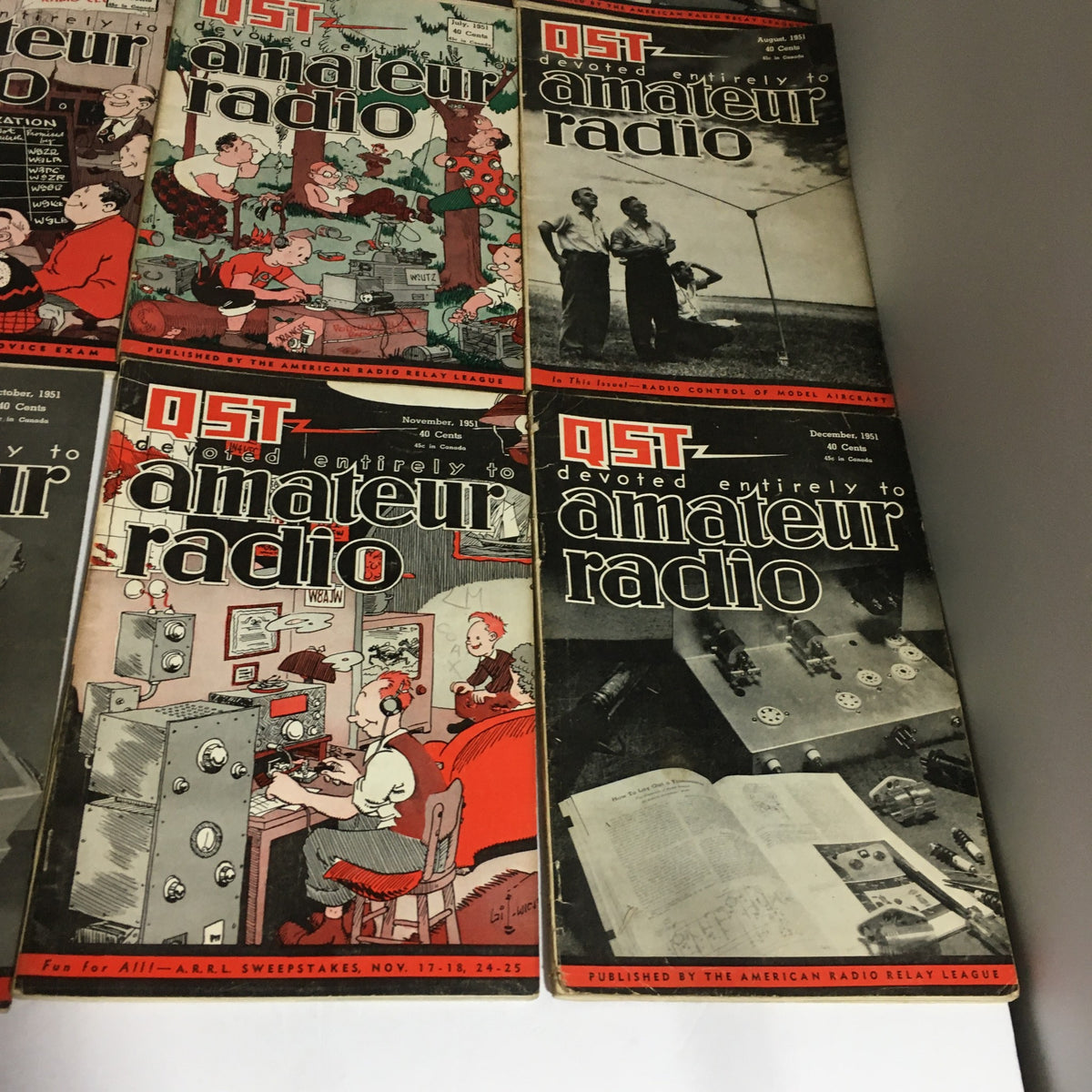 Lot of 12 Complete January to December 1951 QST Amateur Radio magazines arranged showing artistic illustrations and historical content about amateur radio.