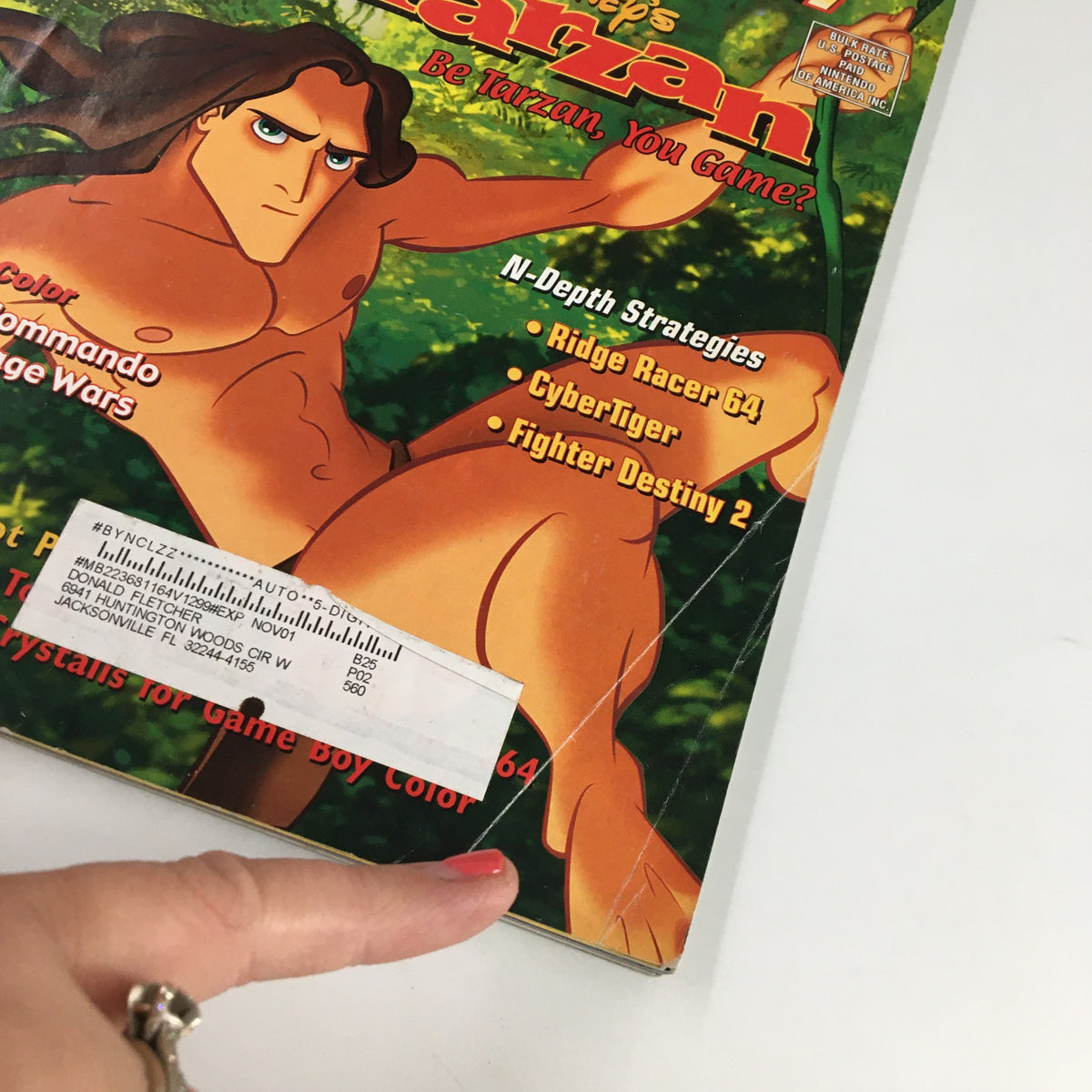 Close-up view of Nintendo Power Magazine Vol. 129 February 2000 cover showcasing Disney's Tarzan with highlighted game strategies and wear details.