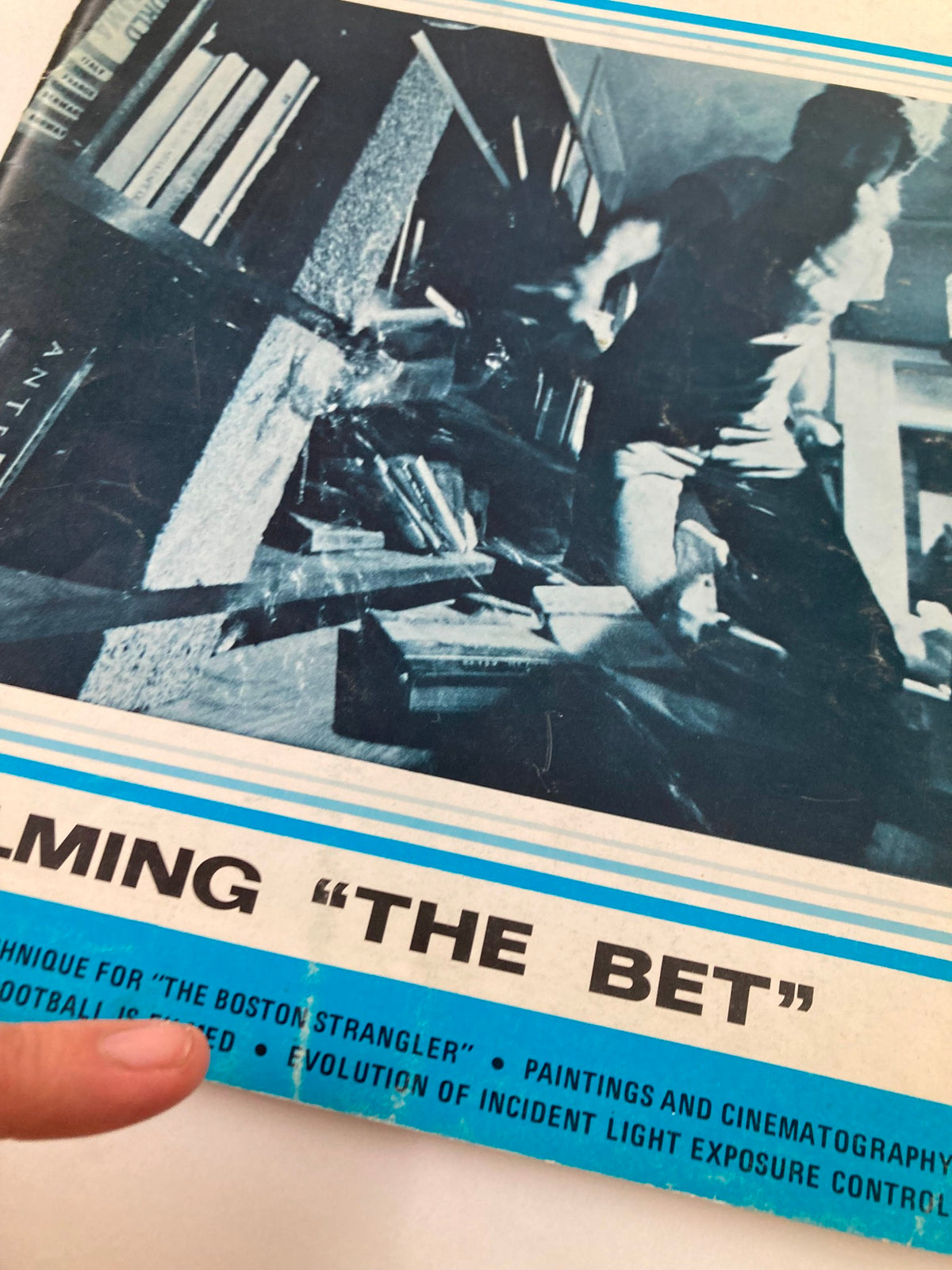 Close-up of the cover of American Cinematographer Magazine February 1969 that highlights the title 'Filming The Bet', with a hand pointing at featured articles.