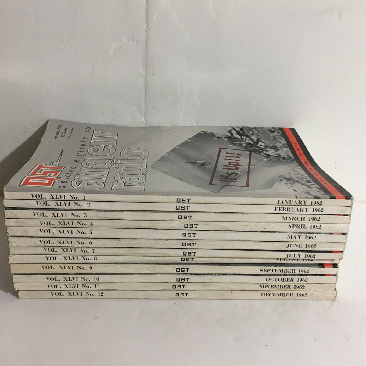 Lot of 12 Complete January to December 1962 QST Amateur Radio presenting a stacked view of the magazine collection sorted by month from January to December.