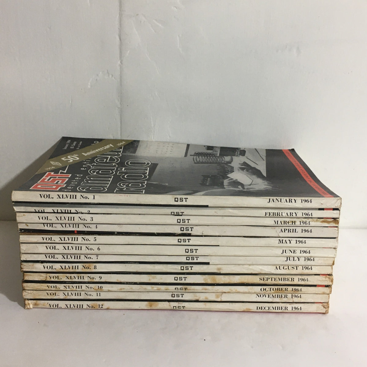 Lot of 12 Complete January to December 1964 QST Amateur Radio magazines, showcasing Volumes 1-12 stacked together with visible covers and publication months.