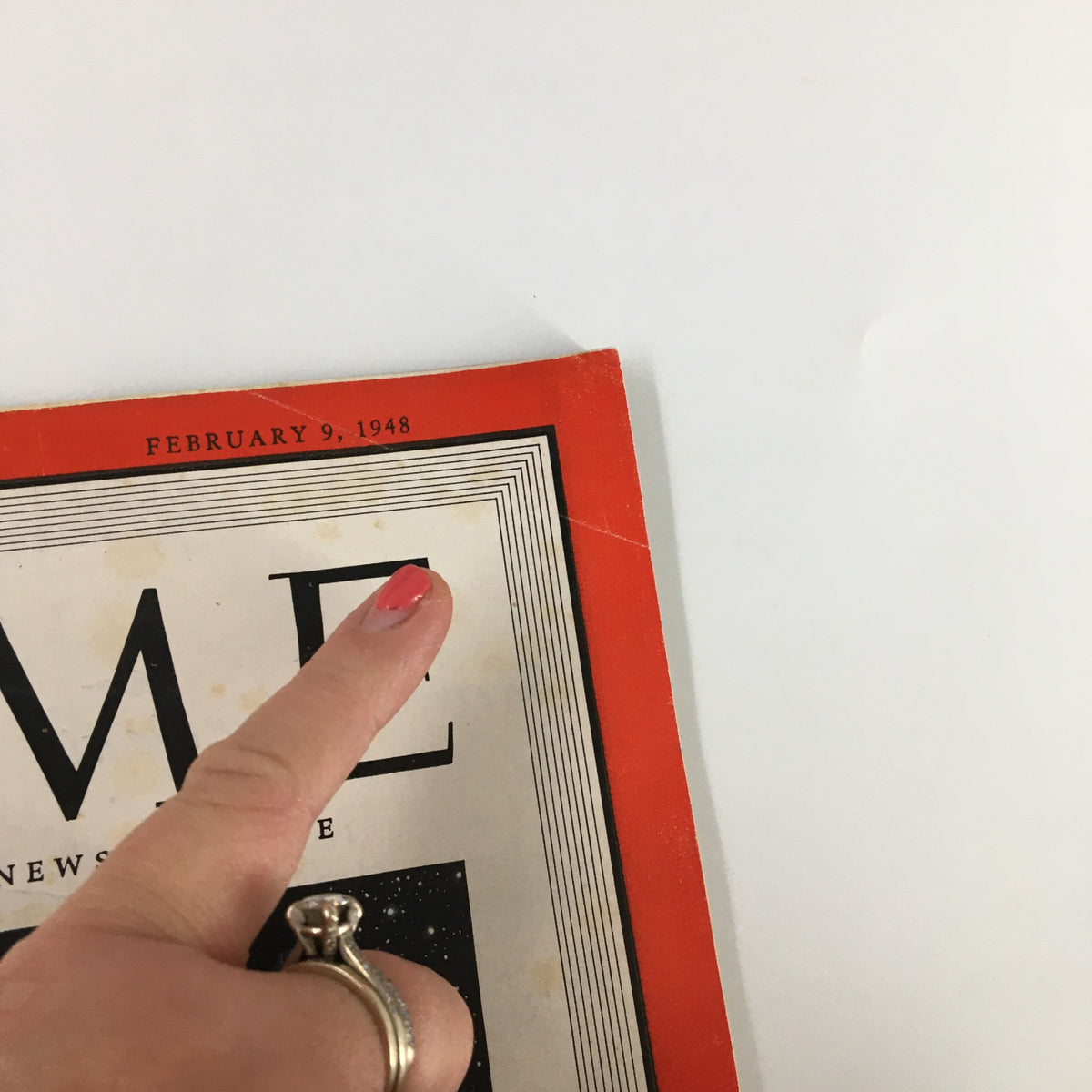 Close-up of the cover of the VTG Time Magazine February 9, 1948, showcasing the date and title, with a finger pointing at the title's edge, illustrating details of the vintage publication.