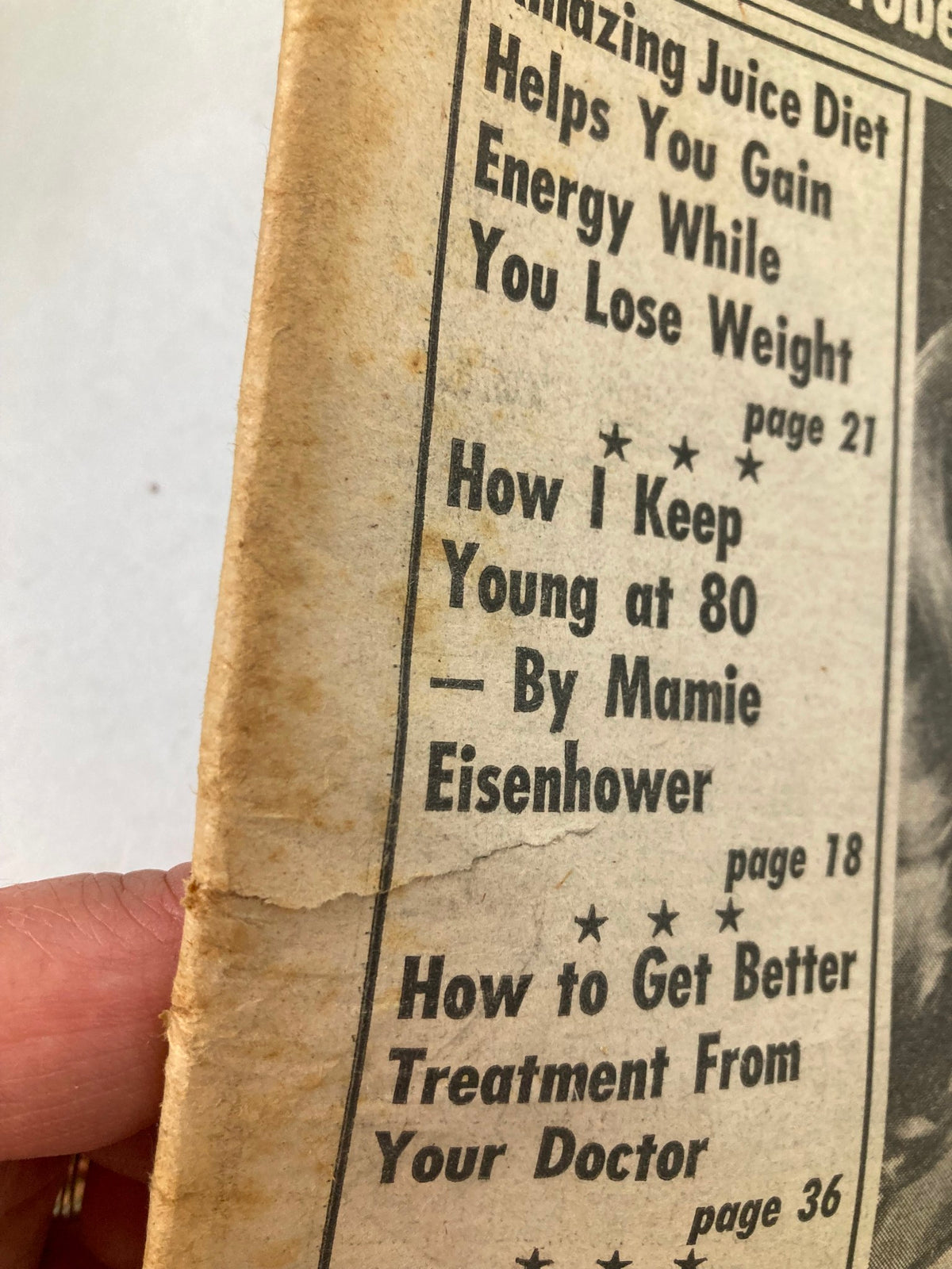 Side view of National Enquirer Tabloid November 16 1976, showing details of articles including 'How I Keep Young at 80' by Mamie Eisenhower, with visible wear on the binding.