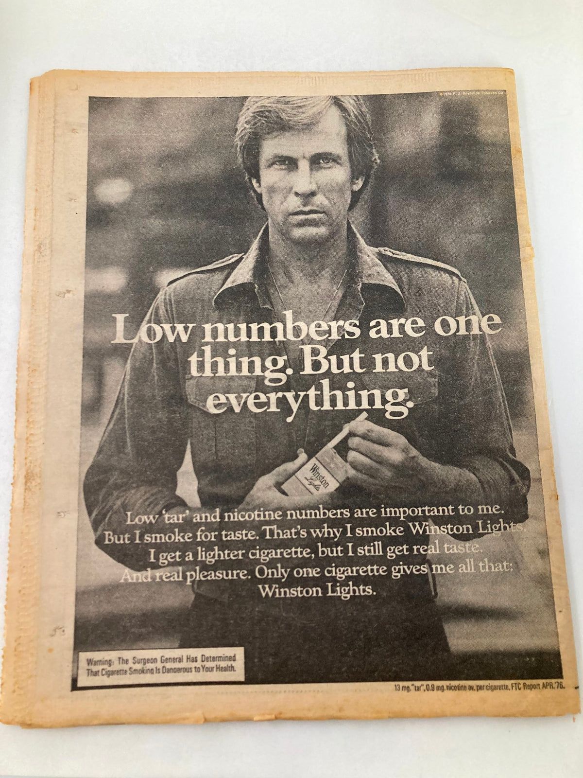 Back cover of National Enquirer Tabloid November 16 1976 showcasing a cigarette advertisement stating 'Low numbers are one thing. But not everything.' Captures the retro marketing of the era.