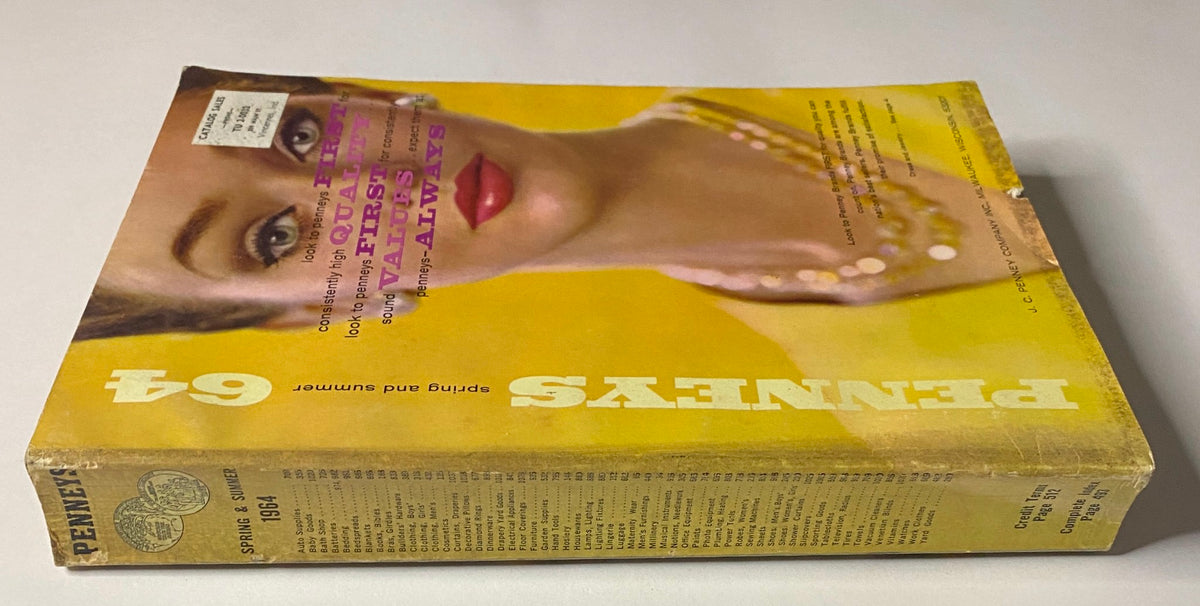 Side view of the 1964 JC Penneys Spring and Summer Catalog displaying the spine and cover with a colorful model image.