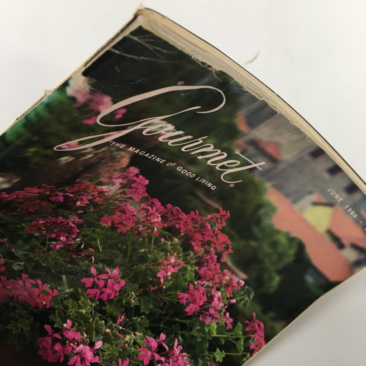 Close-up image of the cover of Gourmet Magazine June 1984 issue titled 'The Lone Marketeer,' featuring pink flowers and detailing the magazine's title and date.