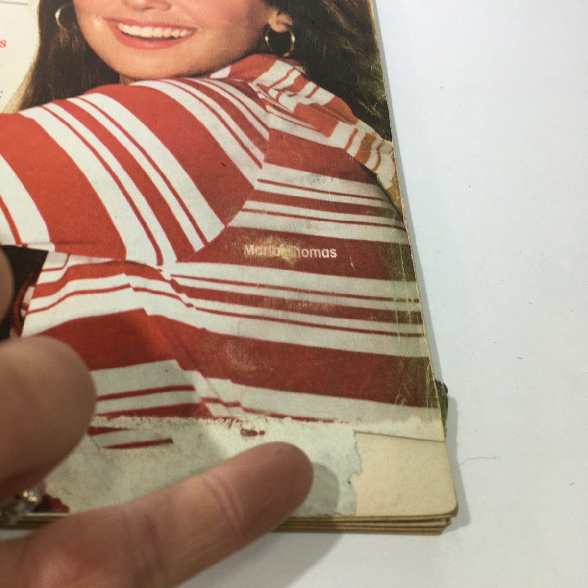 Close-up of the corner of the Good Housekeeping magazine from July 1975 featuring Marlo Thomas. The image shows the magazine cover with iconic red and white stripes, capturing the vintage style of the era.