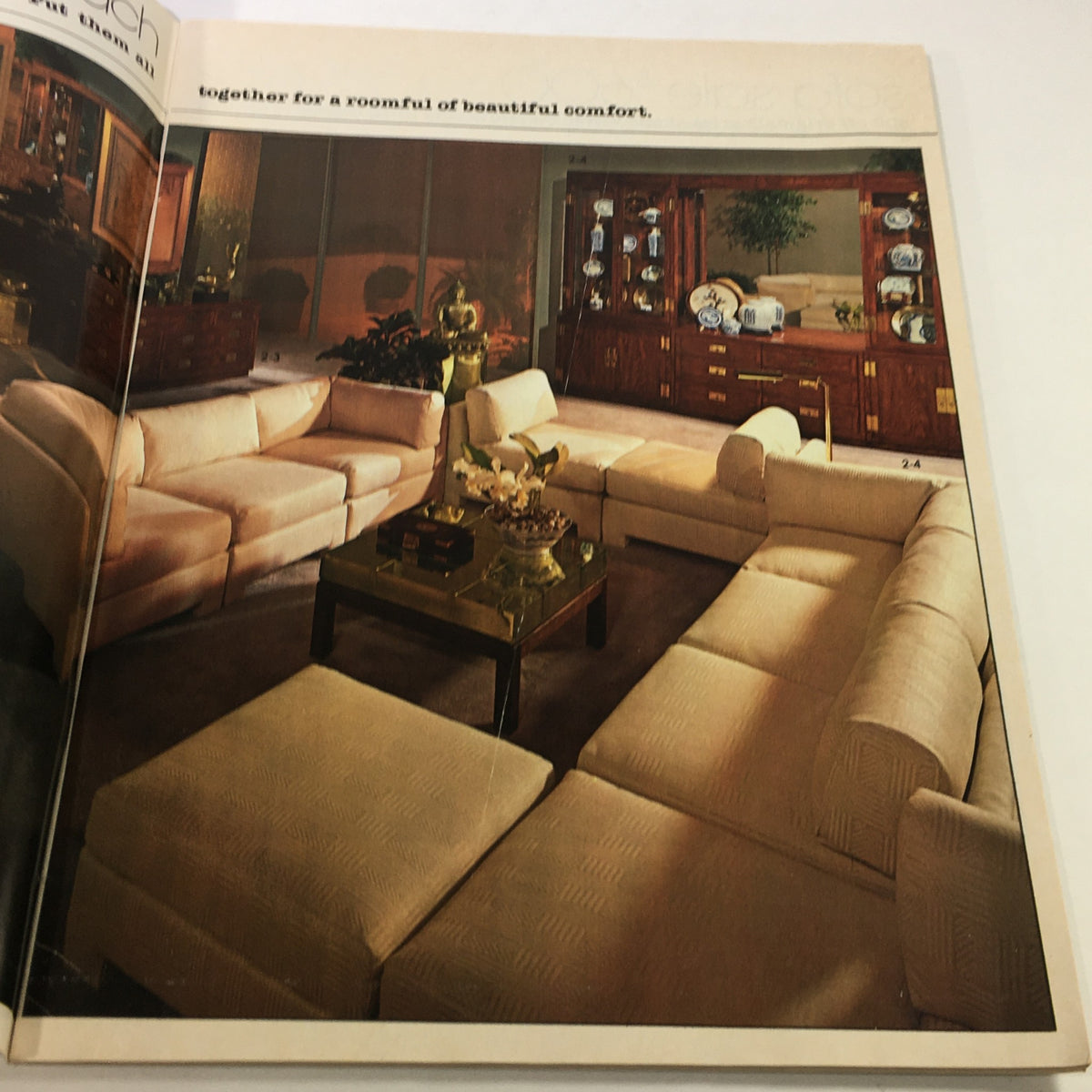 VTG Macy's Catalog: February 1979 showcasing a modern living room setting with an L-shaped sofa, decorative furnishings, and a coffee table, emphasizing beautiful comfort.