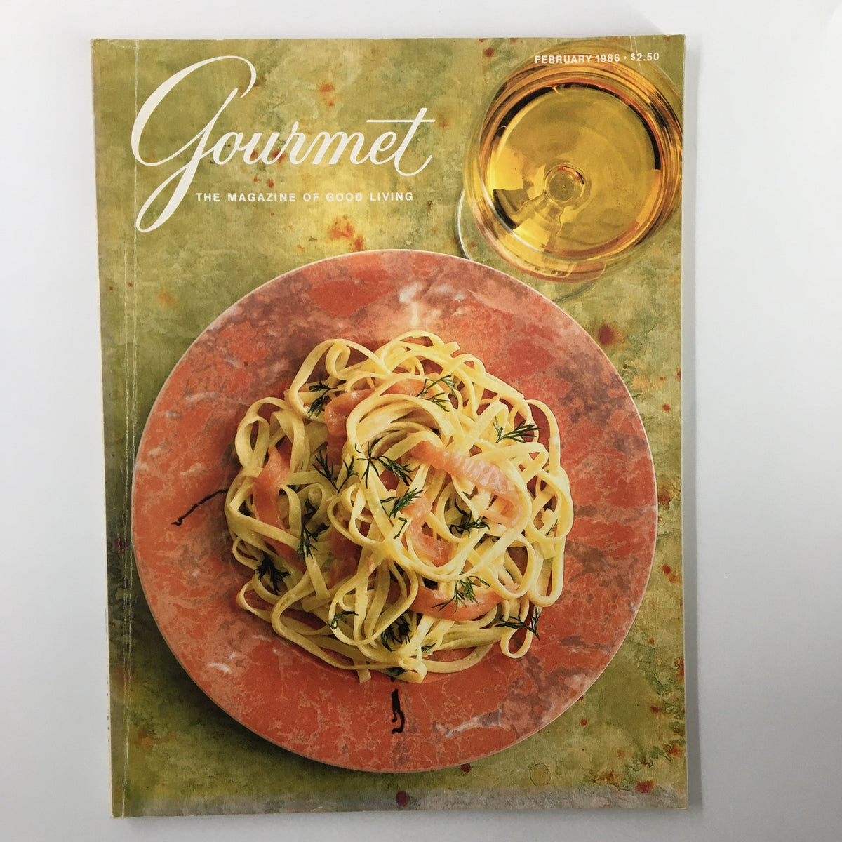 Cover of VTG Gourmet Magazine February 1986 titled 'Versailles Beyond The Palace' featuring a plate of fettuccine decorated with herbs and a glass of drink, emphasizing fine dining and culinary arts.