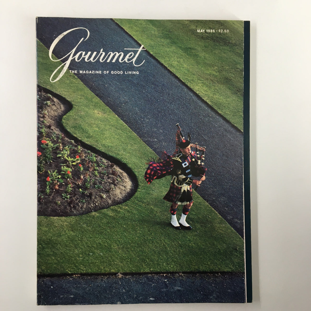 Cover of VTG Gourmet Magazine May 1986 featuring a bagpiper standing on a manicured lawn, showcasing the elegance of the Turnberry Hotel and Golf Courses.