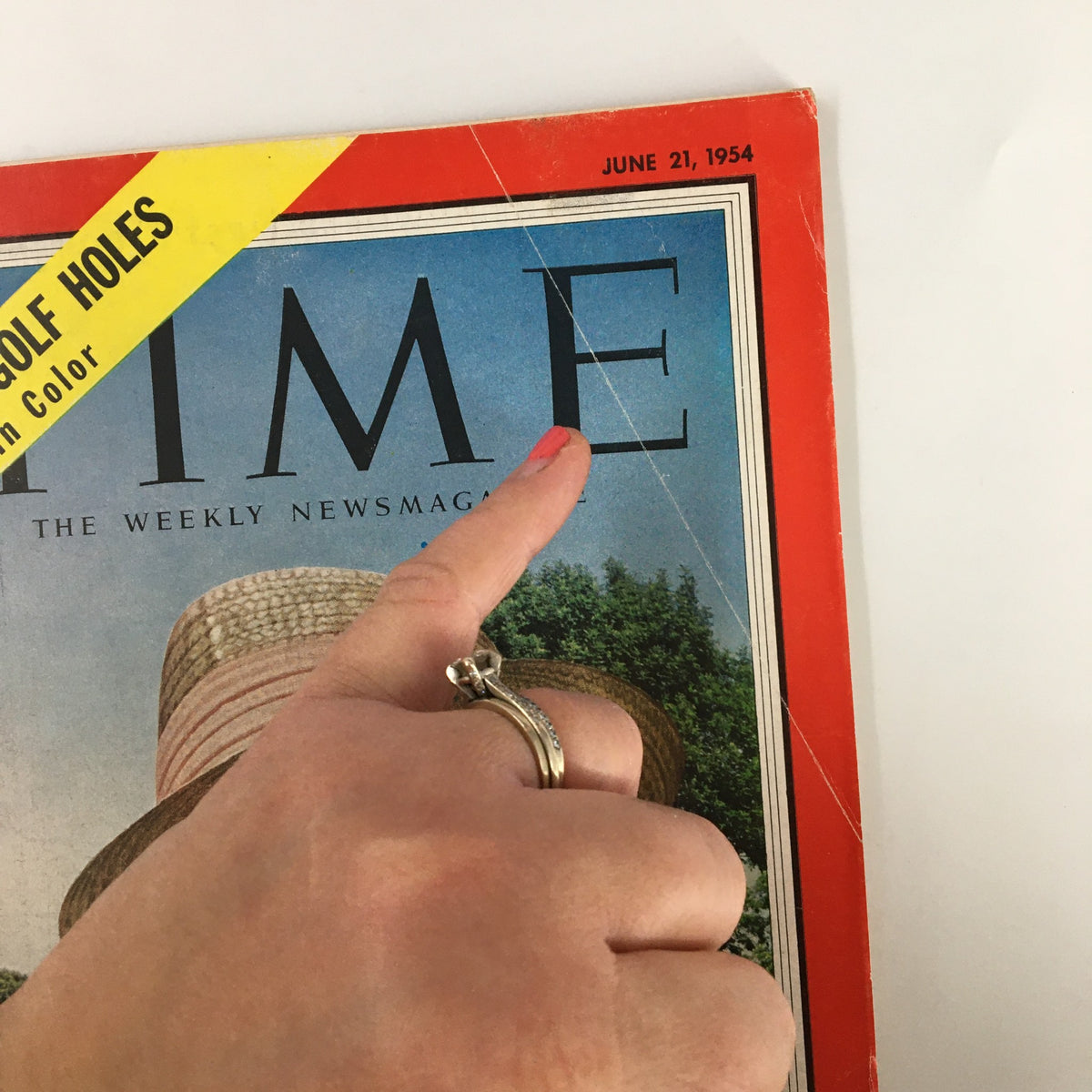 Close-up of the cover of VTG Time Magazine June 21, 1954, features a highlighted text about famous golf holes and a hand pointing at the 'TIME' logo.