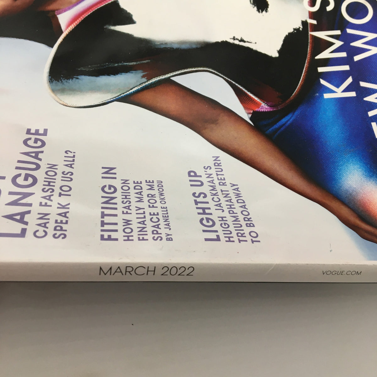 Close-up view of the March 2022 edition of Vogue Magazine featuring Kim Kardashian on the cover, highlighting text elements such as 'Language,' 'Fitting In,' and 'Lights Up.' This iconic issue captures Kim Kardashian's influence in fashion and culture.