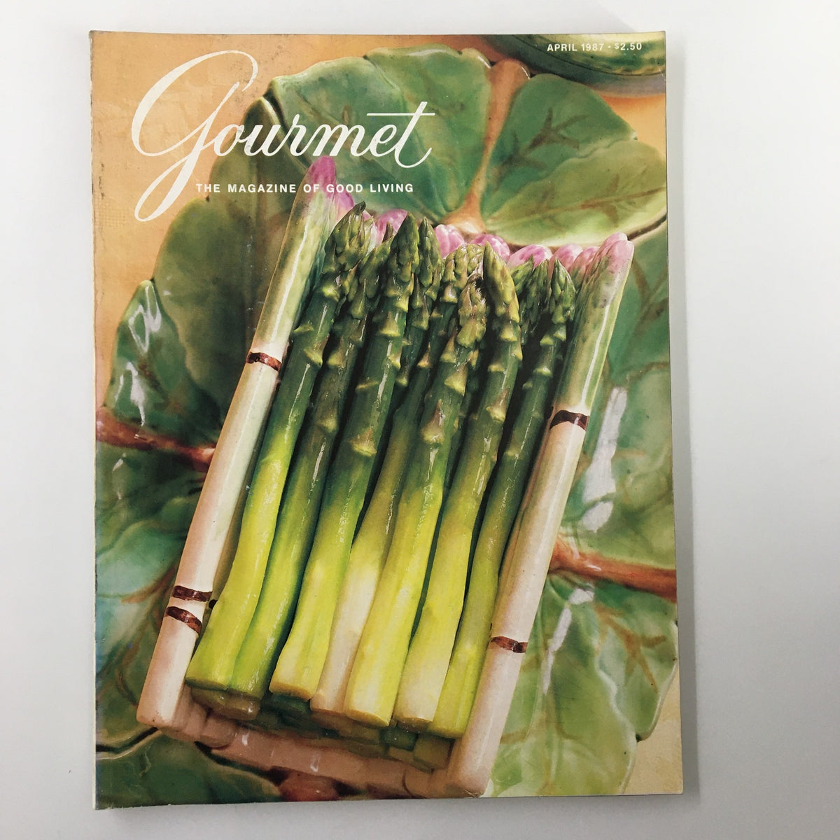 Cover of VTG Gourmet Magazine April 1987 featuring asparagus on a leaf backdrop, highlighting gourmet cooking and recipes for Hollandaise and Béarnaise sauces.