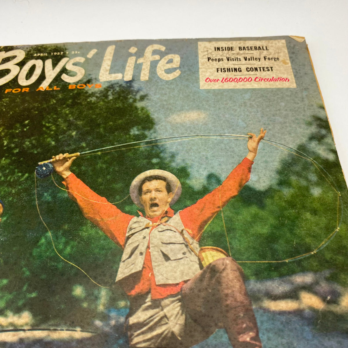 Close-up of the cover of VTG Boys' Life for All Boys Magazine, April 1957, highlighting a man in red celebrating a fishing triumph, showcasing nostalgia and vintage charm.