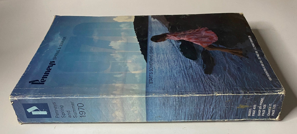 Side view of the 1970 JC Penneys Spring and Summer Store Catalog showing the spine with a woman in a pink dress on the cover beside serene water.