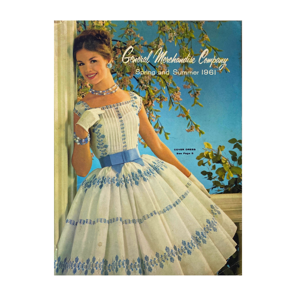1961 General Merchandise Company Spring and Summer Catalog cover featuring a woman in a vintage dress with blue embroidery, showcasing the fashion of the early 1960s.