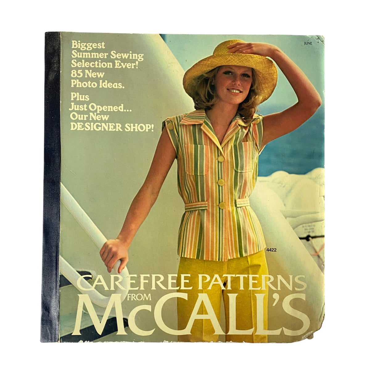 1975 June Carefree Patterns McCall's Catalog cover featuring a woman in a striped outfit and wide-brimmed hat, advertising summer sewing selections and designer shop openings.