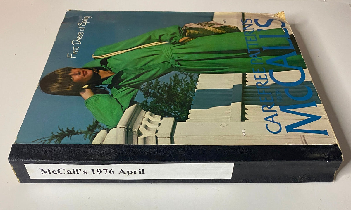 Side view of the 1976 April Carefree Patterns McCall's Spring Catalog showing a model in a green dress, with a white fence in the background.