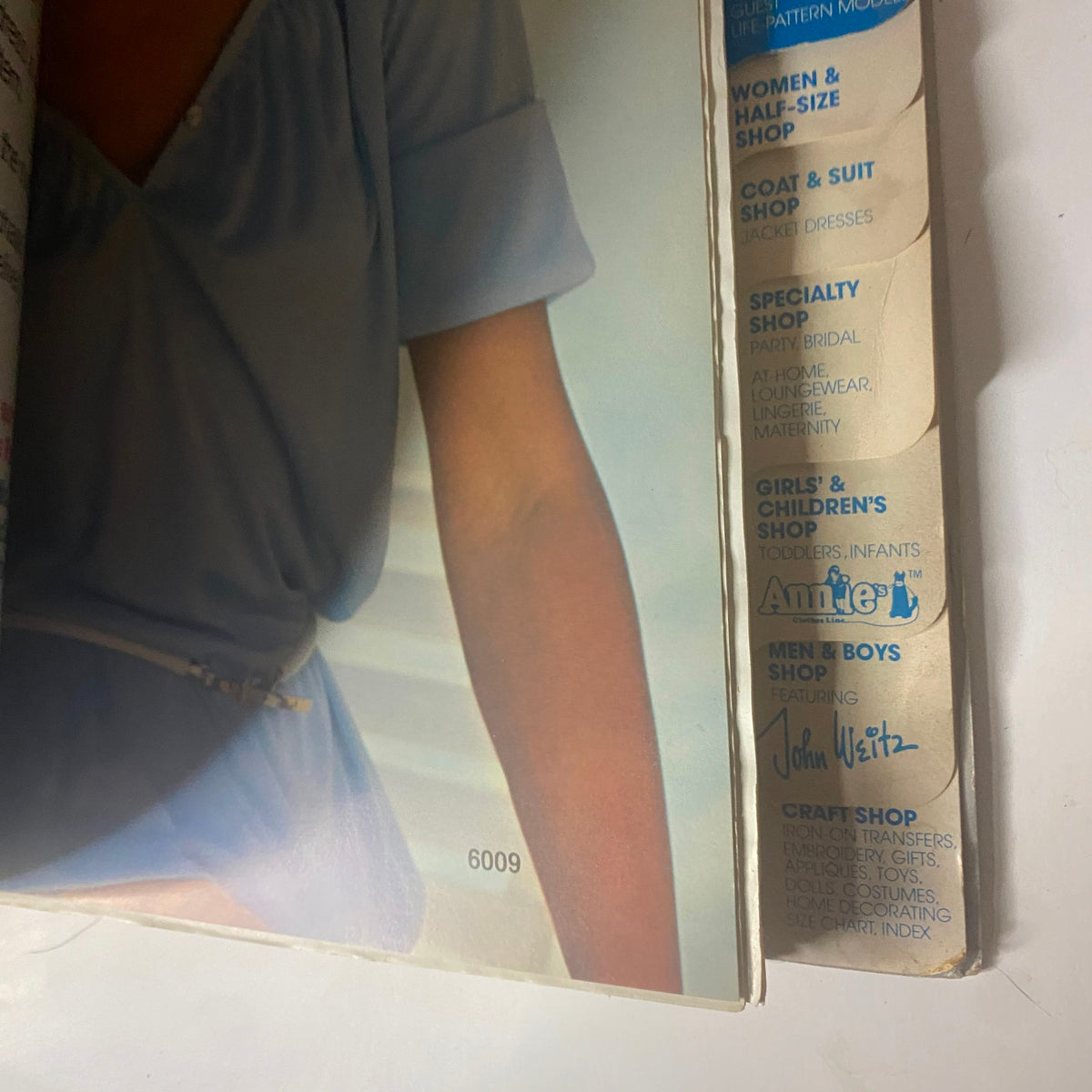 Close-up of a model showcasing a blue garment from the 1970s June Carefree Patterns McCall's Huge Store Retail Counter Catalog, emphasizing fashion from the era.