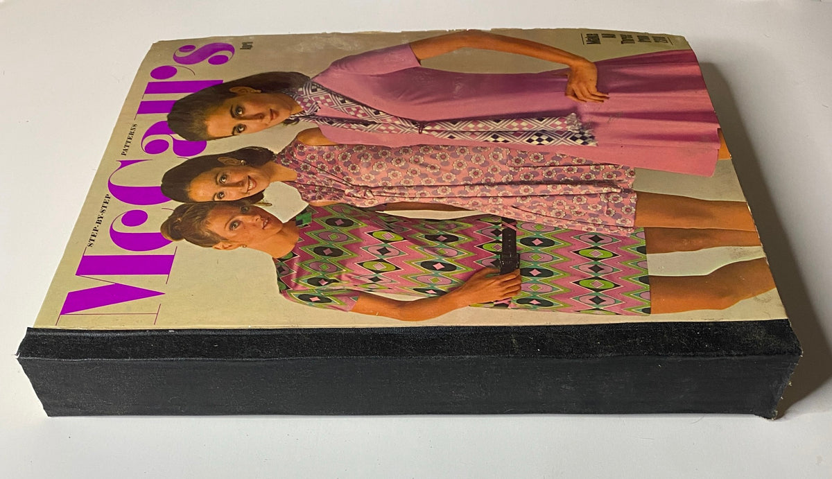 Side view of the 1960s April McCall's Step-by-Step Pattern Catalog highlighting the stylish cover design with models in colorful outfits.