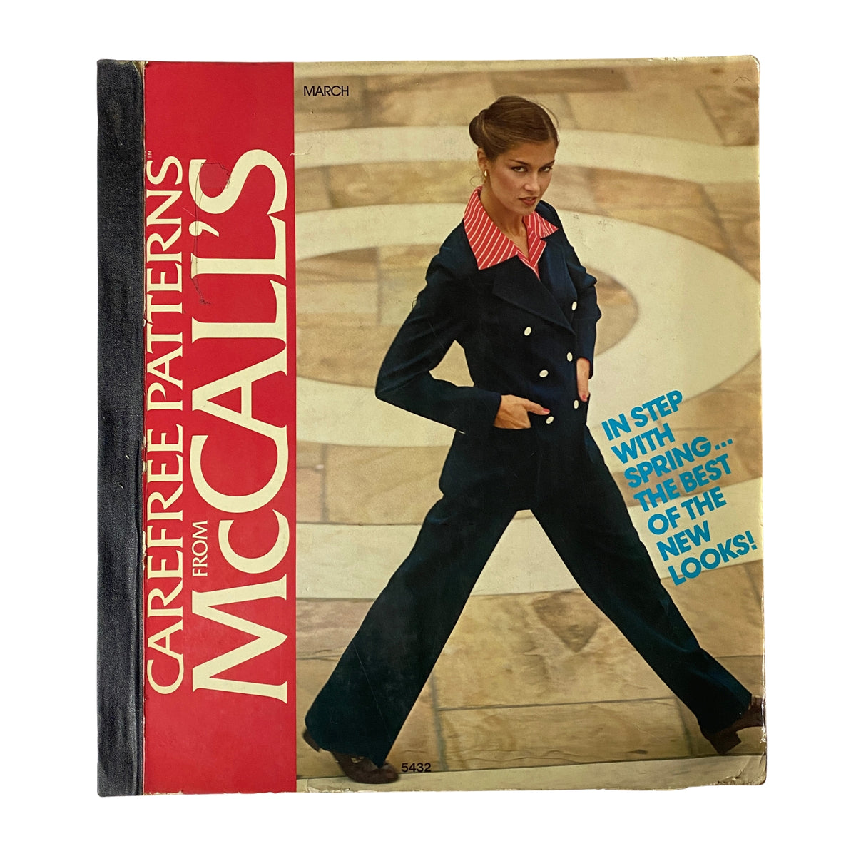 Cover of the 1970s March Carefree Patterns from McCall's Catalog featuring a model in a stylish navy suit with a pink striped collar, showcasing fashion designs for spring.