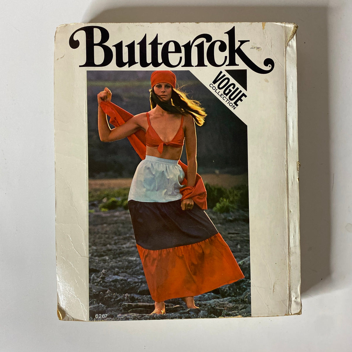 Cover image of the 1971 July Butterick Vogue Collection Catalog featuring a model in a vibrant outfit. Highlights various vintage patterns available in the catalog, ideal for sewing enthusiasts.