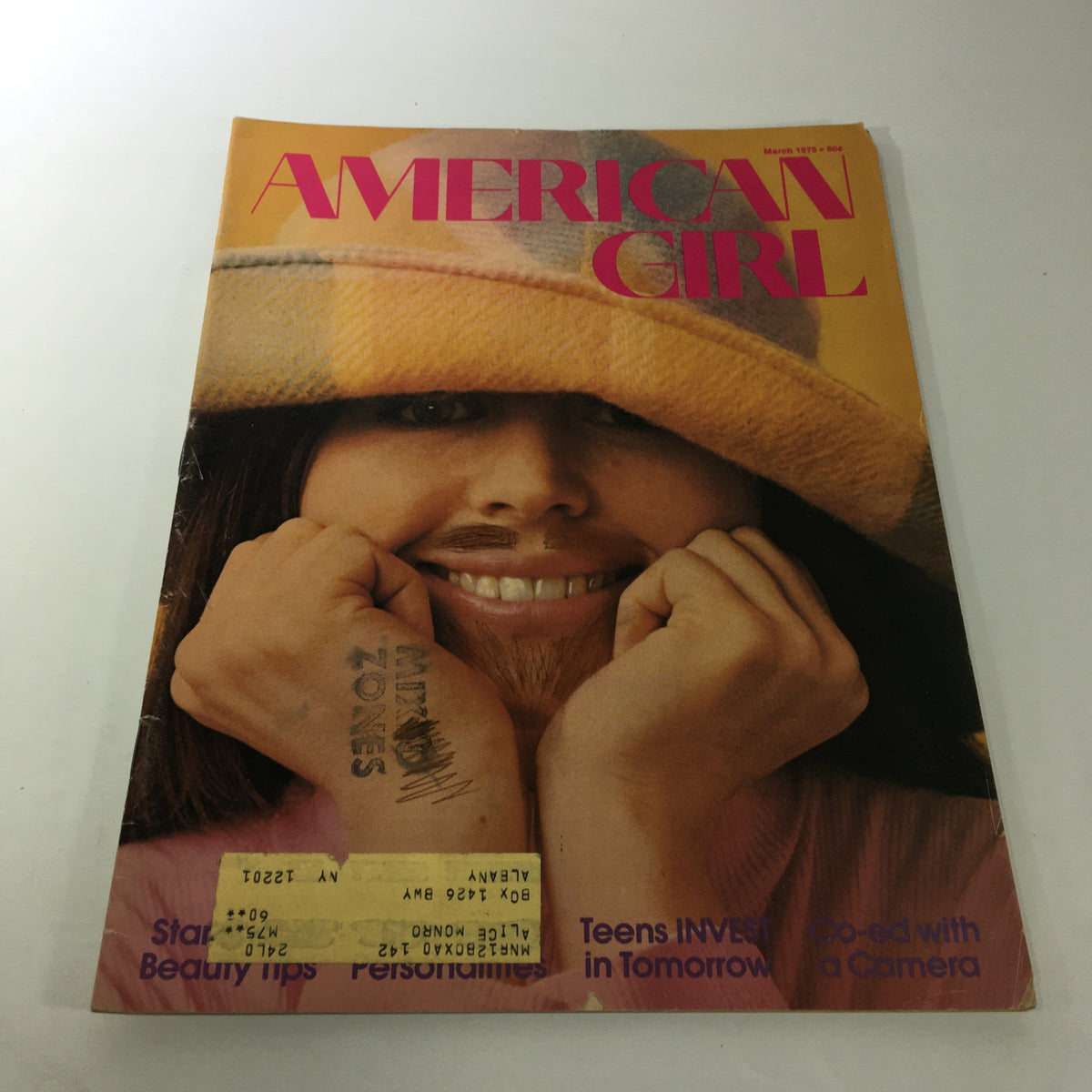 Cover of VTG American Girl Magazine March 1975 featuring a smiling girl wearing a large hat with the headline 'Teens Invest In Tomorrow' and tips on beauty.