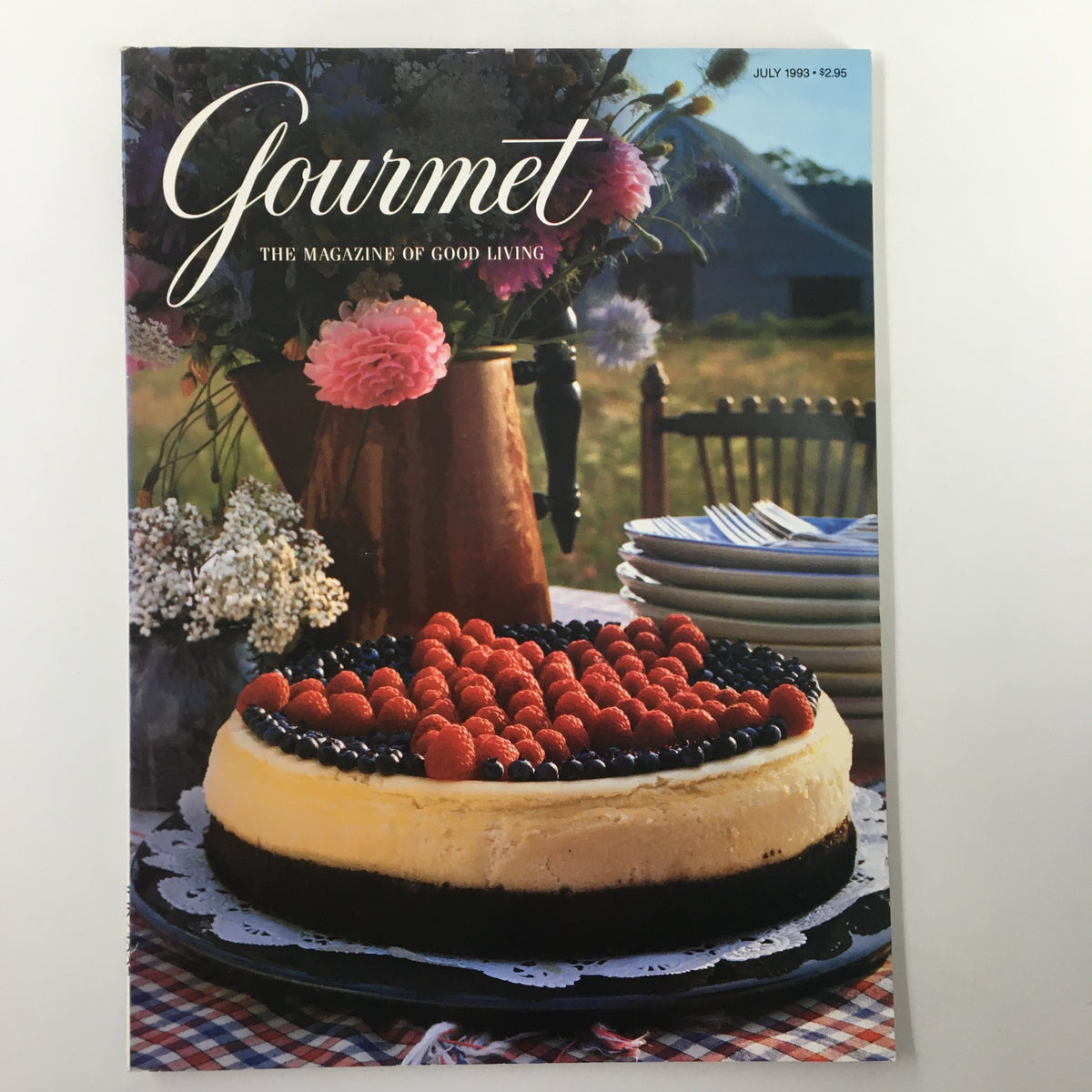 Gourmet Magazine July 1993 cover featuring a cheesecake topped with raspberries and blueberries, set on a table decorated with flowers and a country background. The title reads 'Gourmet: The Magazine of Good Living'.