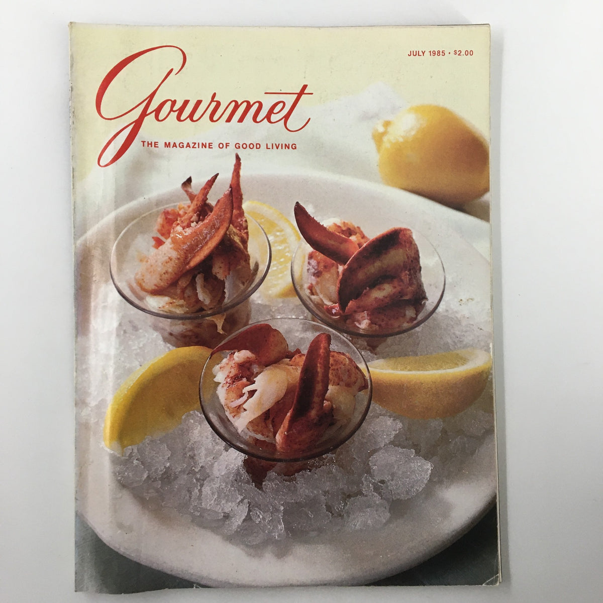 Cover of VTG Gourmet Magazine July 1985, featuring Lobster Cocktail at a New York restaurant, highlighting elegant culinary presentation on ice with lemon slices.